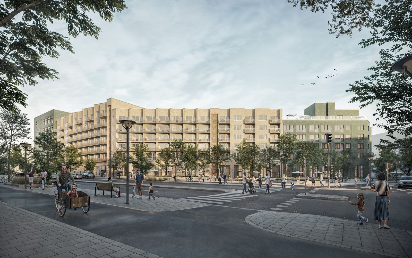 Kvarter 12 sett från gatan: ett ljust tegelkvarter i sex till sju våningar med balkonger, lokaler i bottenvåningen och en grön gavel mot hörnet